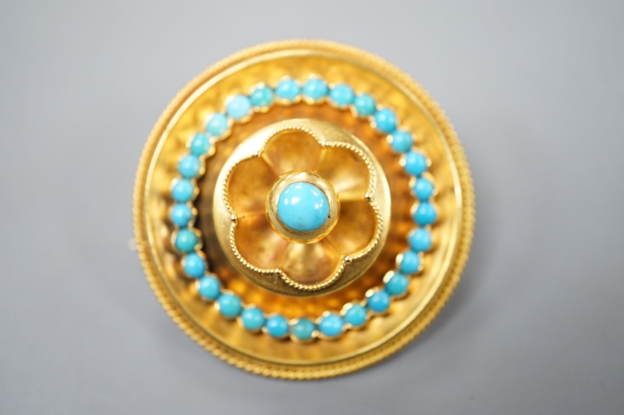 A Victorian yellow metal and turquoise cluster set circular brooch, with glazed back, 34mm